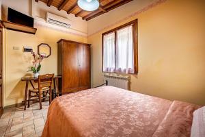 1 dormitorio con cama, mesa y ventana en Agriturismo Cesani, en San Gimignano