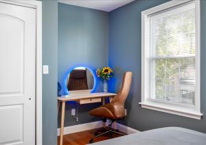 Dieses blaue Zimmer verfügt über einen Schreibtisch mit einem Spiegel und einem Stuhl. in der Unterkunft Colorful, Comfy & Modern - Close to NYC - Parking! in Mount Vernon
