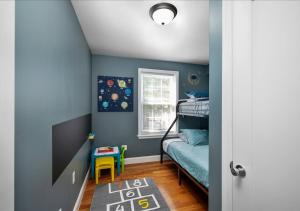 Colorful, Comfy & Modern - Close to NYC - Parking! في Mount Vernon: غرفة نوم بجدران زرقاء وسرير بطابقين