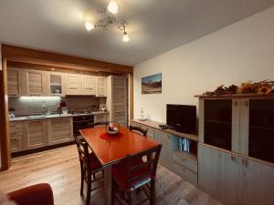 a kitchen with a wooden table and a dining room at Casa Vacanze Cesco Resia in San Pietro di Cadore