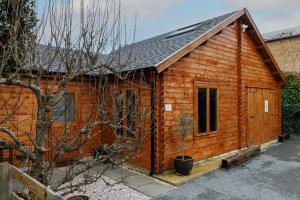 a wooden cabin with a window and a roof at Spacious Log Cabin with Parking near Cambridge in Cambridge