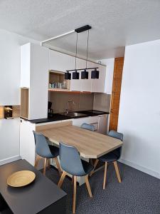 阿雷特的住宿－Studio Moderne au pied des pistes 4 Pers - La Pierre Saint-Martin GR10，厨房配有木桌和椅子