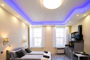 - un salon avec un lit et un plafond avec un éclairage violet dans l'établissement GrigorasNCo Studio Apartments, à Budapest