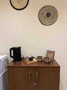 a wooden cabinet with a coffee maker on top of it at Brown vibes comfy studio in Jeddah