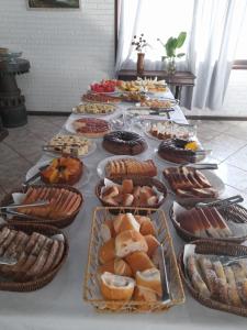 a table full of different types of pastries and desserts at Vitória Torres Hotel in Torres