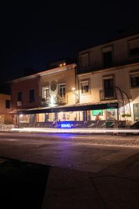 a building with lights on a street at night at Naval Guest House & Bistrô in Vila do Conde