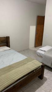 een slaapkamer met 2 bedden en een houten deur bij Casa Califórnia in Lindóia