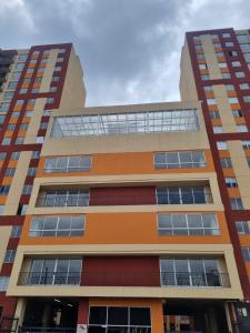 a tall building with orange at Alquiler Apartamento en Bogotá cerca al aeropuerto-Colibri Dorado in Bogotá