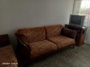 salon z kanapą i telewizorem w obiekcie Deniz Yıldızı Apart w mieście Marmaraereglisi