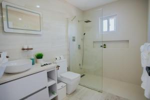 uma casa de banho com um WC, um lavatório e um chuveiro em Hidden Villa Aruba em Oranjestad