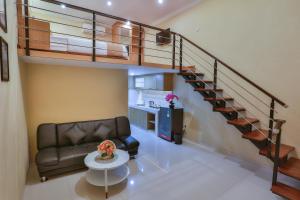 a living room with a couch and a spiral staircase at The Horizontal Hotel Pacitan in Pacitan