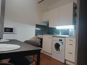 a kitchen with a washing machine and a table at Apartmán Brno-Bystrc in Brno