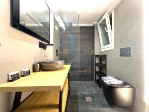 uma casa de banho com um lavatório e um WC. em Osiris Hideaway Inn, Kerameikos, Athens, Industrial 2-br apt, balconies & Netflix em Atenas