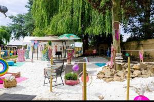 uma área recreativa com uma caixa de areia e uma árvore em Bed and breakfast aan de grens em Lanaken