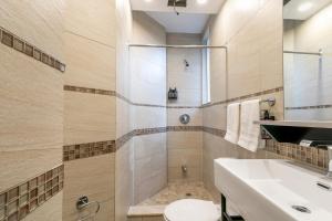 a bathroom with a shower and a toilet and a sink at hotel le coach in Montréal