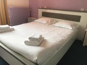 uma cama com toalhas brancas em cima em Hotel Bar Restaurant Couleurs Sud em Charleville-Mézières