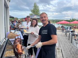 a man and woman standing next to a table with a turkey at Haus PEAK am See in Zirkow