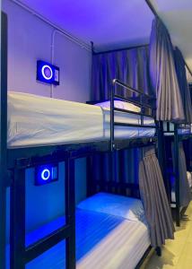 two bunk beds in a room with blue lights at LONGDOO Hostel in Phi Phi Don