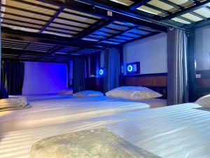 sypialnia z 2 łóżkami z niebieskimi światłami w obiekcie LONGDOO Hostel w Ko Phi Phi