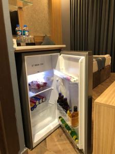 埃尔比勒埃森纳帕酒店的装满饮料和饮料的开放式冰箱