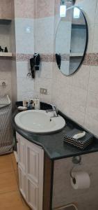 ein Bad mit einem Waschbecken und einem Spiegel in der Unterkunft DIMORA DANICLA in Neapel