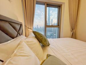 a bedroom with a bed with a large window at Downtown, Burj Khalifa Views, Dubai Mall Connected in Dubai