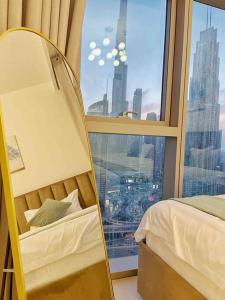 Zimmer mit einem Fenster, einem Bett und einem Spiegel in der Unterkunft Downtown, Burj Khalifa Views, Dubai Mall Connected in Dubai