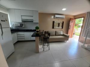 a kitchen and living room with a couch and a table at Golden Apartament's Porto de Galinhas in Porto De Galinhas
