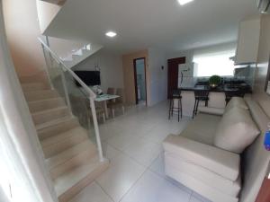 a living room with a staircase and a white couch at Golden Apartament's Porto de Galinhas in Porto De Galinhas