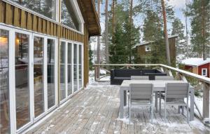 a deck with a table and chairs on a house at 2 Bedroom Cozy Home In Klssbol in Klässbol