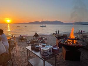 una playa con una mesa con platos y chimeneas en Casa Nelly en Porticcio