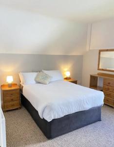 een slaapkamer met een groot wit bed en 2 nachtkastjes bij The Robins Rest in Killarney