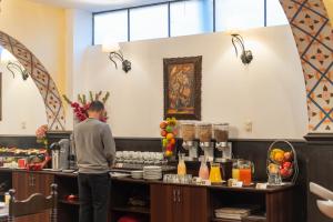 a man standing at a counter in a kitchen at Casona Plaza Hotel Centro in Puno