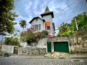 un bâtiment avec une tour au sommet d'un mur dans l'établissement Santa Teresa RJ, à Rio de Janeiro