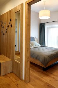 a bedroom with a large bed and a mirror at Apartmány Horizont in Loučná pod Klínovcem