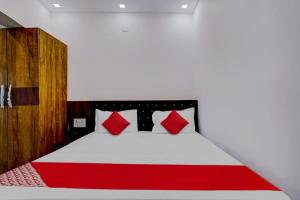 a bedroom with a red and white bed with red pillows at Oxygen in Rānchī