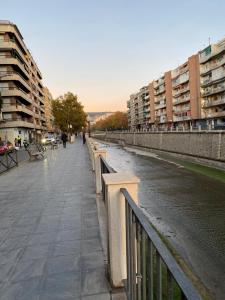 una pasarela junto a un río junto a los edificios en Apartamento Granada centro en Granada