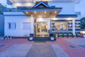 Casa blanca con entrada delantera con macetas en Stone Wood Mountain Resort, Dharamshala, en Dharamshala