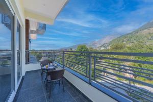 balcón con 2 sillas y vistas a las montañas en Stone Wood Mountain Resort, Dharamshala, en Dharamshala