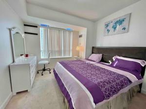een slaapkamer met een paars bed en een bureau bij Magnificent 2bed 2bath Condo in Mississauga