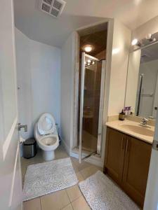 y baño con aseo, lavabo y ducha. en Magnificent 2bed 2bath Condo en Mississauga