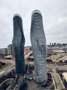 two tall glass skyscrapers in a city at Magnificent 2bed 2bath Condo in Mississauga