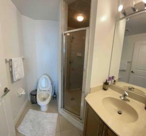 a bathroom with a shower and a sink and a toilet at Magnificent 2bed 2bath Condo in Mississauga