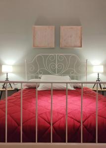 - une chambre avec un lit rouge et deux lampes dans l'établissement Capinera Luxury, à Catane