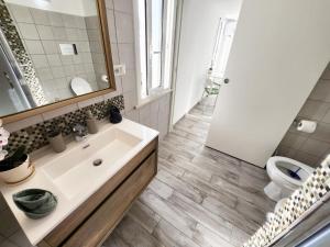 Un baño con lavabo, inodoro y espejo. en Casa al mare Orchidea - Motoparking - Wifi Free - AC, en Cala Gonone 24 fotos más