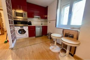 a kitchen with red cabinets and a washer and dryer at Catedral Centro- 4 plazas in Burgos