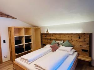 Schlafzimmer mit einem großen Bett mit einem Kopfteil aus Holz in der Unterkunft Finks Appartement in Going