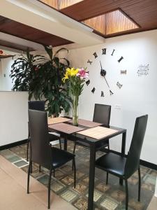 mesa de comedor con sillas y reloj en la pared en Casa Tundama, en Duitama