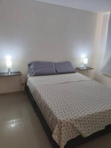 um quarto com uma cama com dois candeeiros em duas mesas em Precioso apto con un aire acondicionado en la Sala em Ricaurte