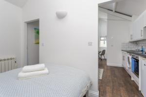 a white room with a bed and a kitchen at Stylish Self-Contained Annex near City Centre in Southampton
